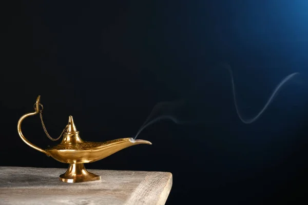 Aladdin lâmpada mágica na mesa contra fundo escuro — Fotografia de Stock