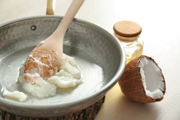 Pfanne mit Kokosöl auf dem Tisch, Nahaufnahme — Stockfoto