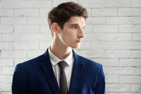 Porträtt av ung affärsman med vackra hår på tegel vägg bakgrund — Stockfoto