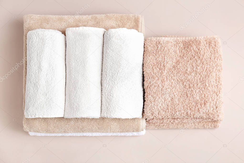 Soft bath towels on grey background, top view