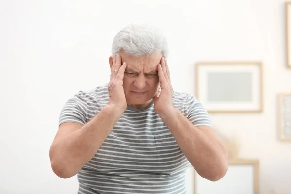 Mature man suffering from headache at home — Stock Photo, Image