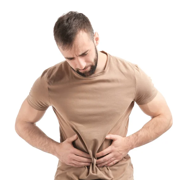 Hombre joven que sufre de dolor abdominal sobre fondo blanco — Foto de Stock