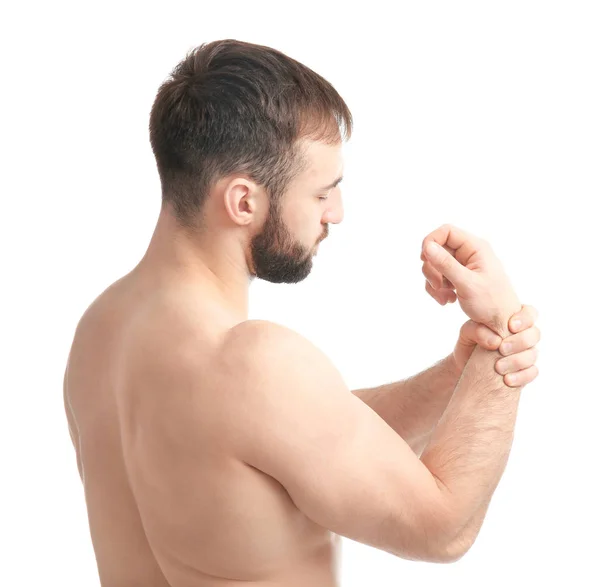 Young man suffering from pain in wrist on white background — Stock Photo, Image