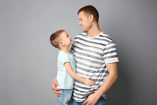 Papà e suo figlio si abbracciano su sfondo grigio. Festa del papà celebrazione — Foto Stock