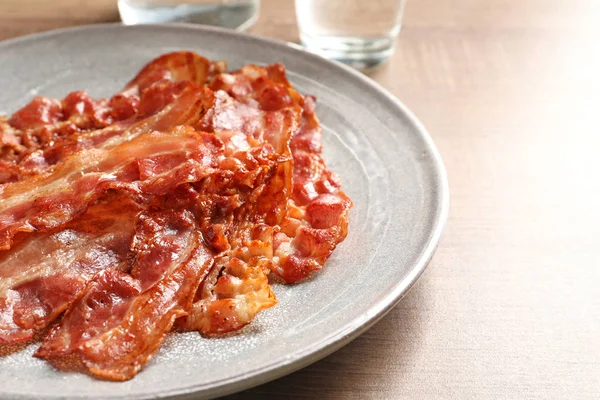 Placa con tocino frito en la mesa —  Fotos de Stock