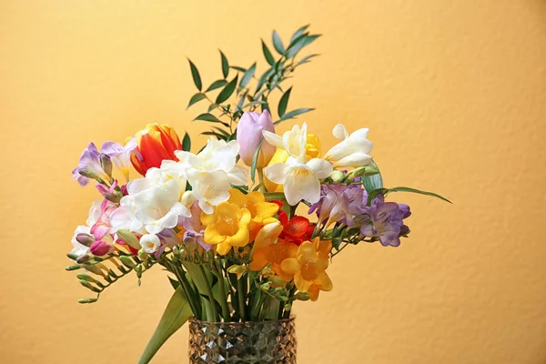 Скляна ваза з красивою фрезією на кольоровому фоні — стокове фото