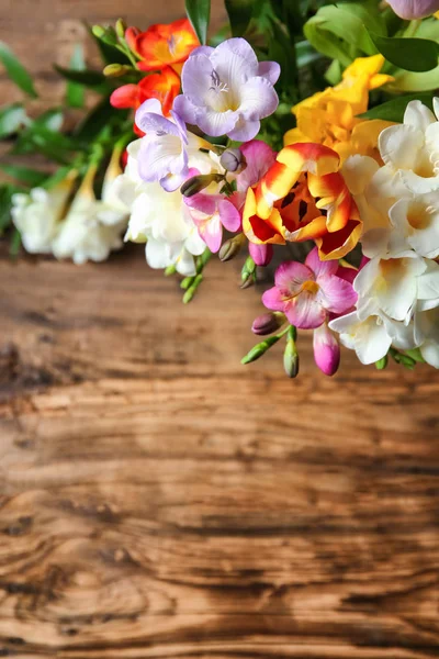 Красивий букет квітів фрезії на дерев'яному столі — стокове фото