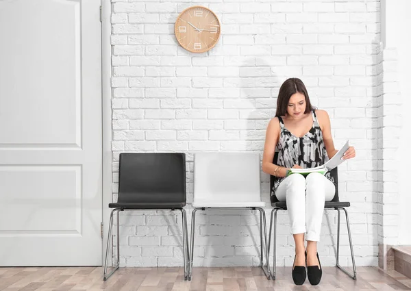 Jonge vrouw te wachten voor het sollicitatiegesprek, binnenshuis — Stockfoto