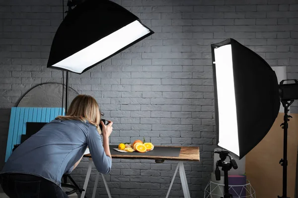 Mujer tomando fotos de comida con cámara profesional en el estudio — Foto de Stock
