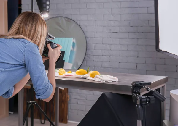 Woman taking photo of food with professional camera in studio — Stock Photo, Image