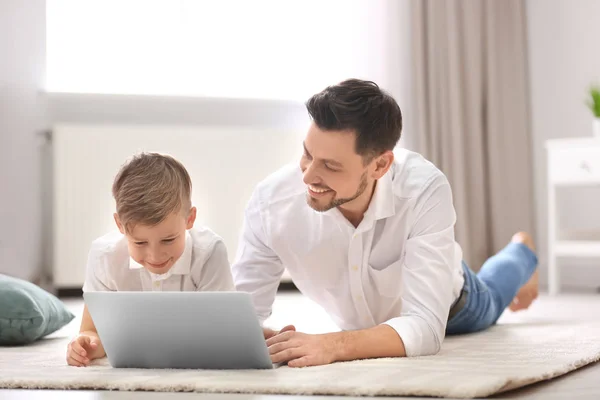 Kleine jongen en zijn papa thuis met behulp van laptop — Stockfoto