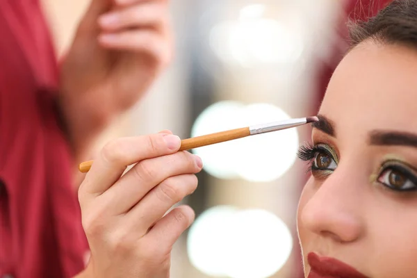 Artista de visagem profissional aplicando maquiagem no rosto da mulher no salão, close-up — Fotografia de Stock