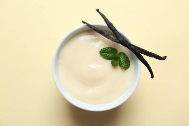 Vanilla pudding, sticks and fresh mint on color background clipart
