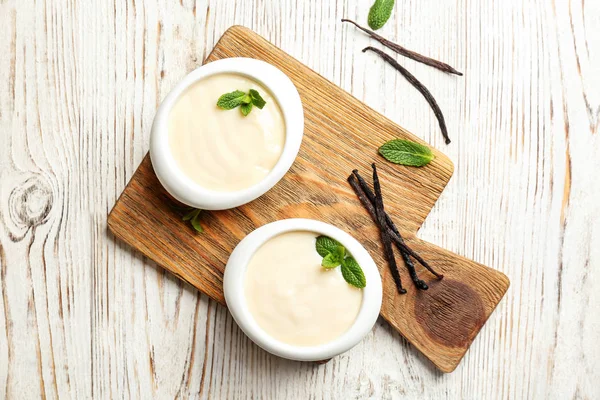 Vanilla pudding, sticks and fresh mint on wooden board — Stock Photo, Image