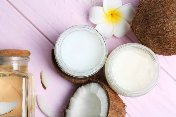 Hermosa composición con aceite de coco y nueces sobre fondo de madera de color — Foto de Stock