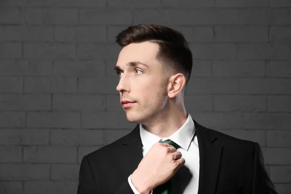 Portrait de jeune homme avec de beaux cheveux sur fond de mur de briques — Photo