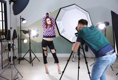 Stüdyoda profesyonel fotoğrafçıya poz veren güzel genç bir model.