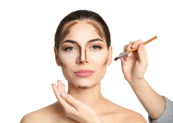 Visage konstnären tillämpa makeup på kvinnans ansikte mot vit bakgrund. Professionella kosmetiska produkter — Stockfoto