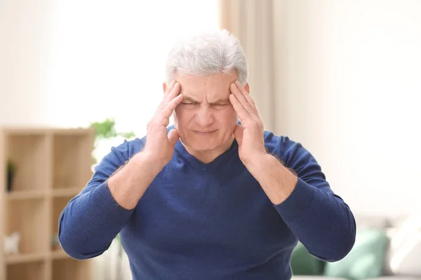 Mature man suffering from headache at home — Stock Photo, Image