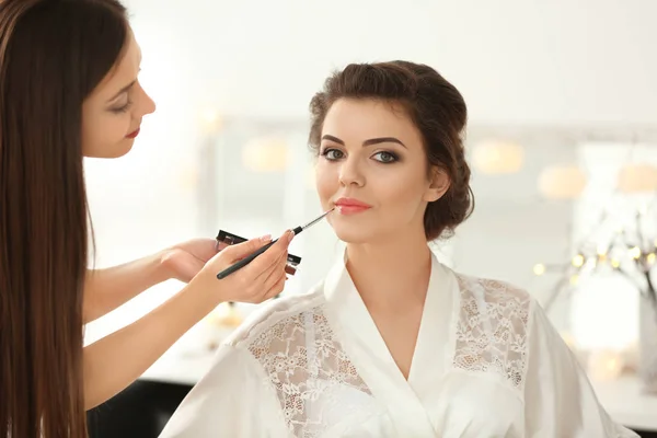 Maquiagem artista preparar noiva antes de seu casamento no quarto — Fotografia de Stock