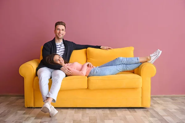 Feliz pareja joven en el sofá, en el interior — Foto de Stock