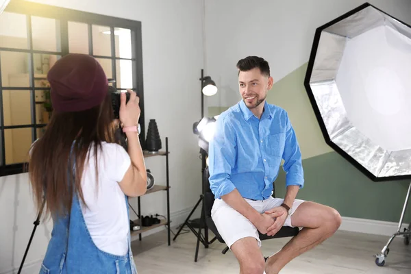 Modelo guapo posando para fotógrafo profesional en estudio — Foto de Stock