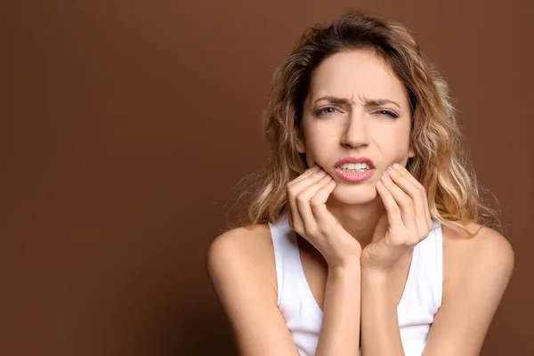 Junge Frau leidet unter Zahnschmerzen vor farbigem Hintergrund — Stockfoto