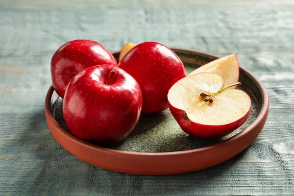 Assiette avec pommes rouges fraîches mûres sur fond en bois — Photo