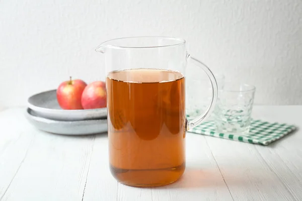 Pot avec jus de pomme frais sur table en bois — Photo