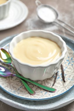 Vanilyalı puding ve plaka üzerinde sopa ile kase