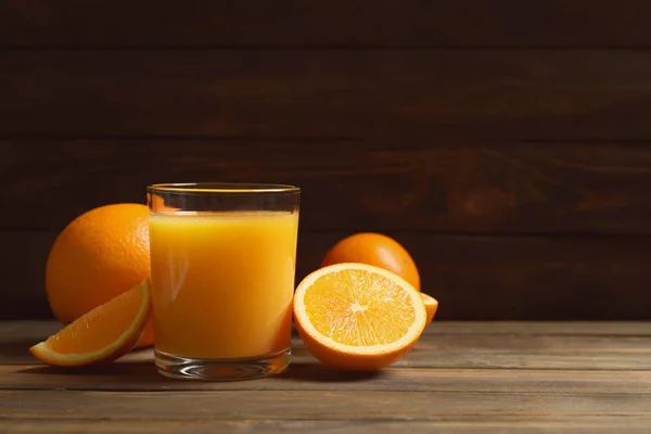 Egy pohár narancslé és friss gyümölcs az asztalon — Stock Fotó
