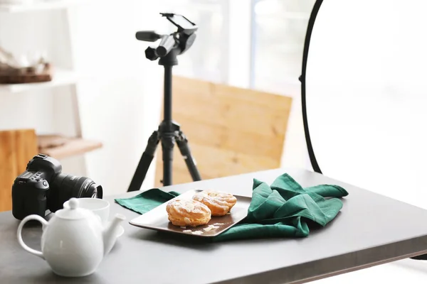 Professional camera and food composition on table in photo studio