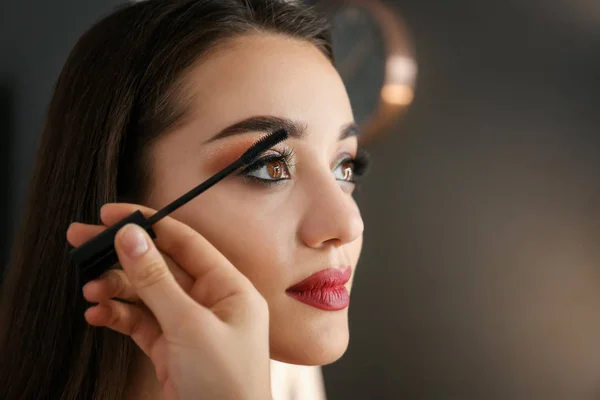 Artista de visagem profissional aplicando maquiagem no rosto da mulher no salão, close-up — Fotografia de Stock