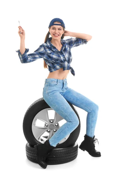 白い背景の上の車のタイヤがある魅惑的な服装の若い女性 — ストック写真