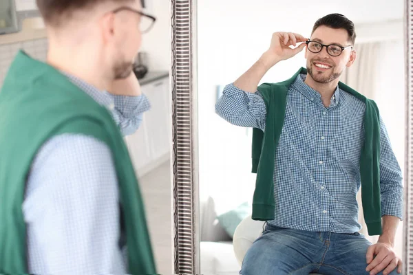 Зрілий чоловік дивиться в дзеркало вдома — стокове фото