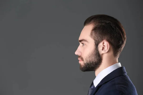 Porträtt av ung affärsman med vackra hår på grå bakgrund — Stockfoto