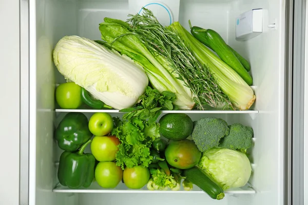 Sayuran hijau dan buah-buahan yang berbeda di atas rak kulkas — Stok Foto