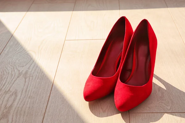 Pair of red female shoes on floor