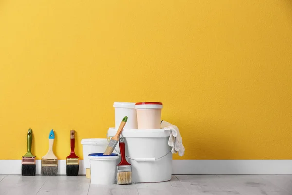 Set avec outils décorateurs et peinture sur le sol près du mur de couleur — Photo