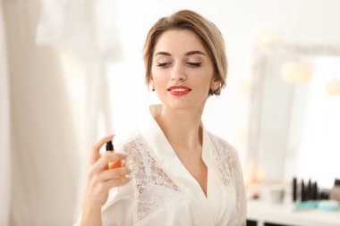 Parfüm şişesi holding güzel genç gelin. Düğün hazırlığı