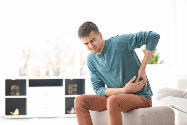 Joven sufriendo de dolor en su lado en casa —  Fotos de Stock