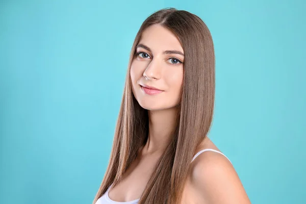 Портрет молодой женщины с длинными красивыми волосами на цветном фоне — стоковое фото