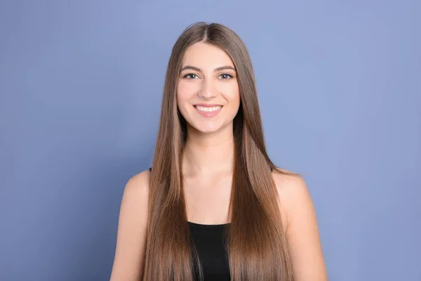 Portret van een jonge vrouw met lange mooie haren op grijze achtergrond — Stockfoto