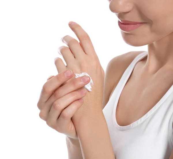 Mujer joven aplicando crema corporal sobre fondo blanco — Foto de Stock