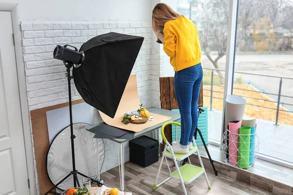 Jovem mulher tirando fotos de limões, hortelã e gengibre em estúdio profissional. Fotografia alimentar — Fotografia de Stock