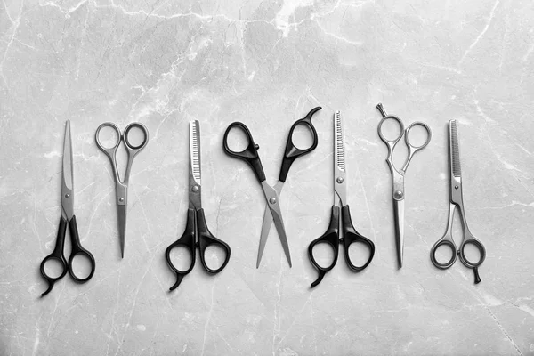 Plochá laických složení s profesionální kadeřnice nůžky na šedém pozadí — Stock fotografie