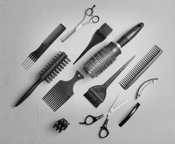 Composizione flat lay con strumenti professionali per parrucchieri su fondo grigio — Foto Stock