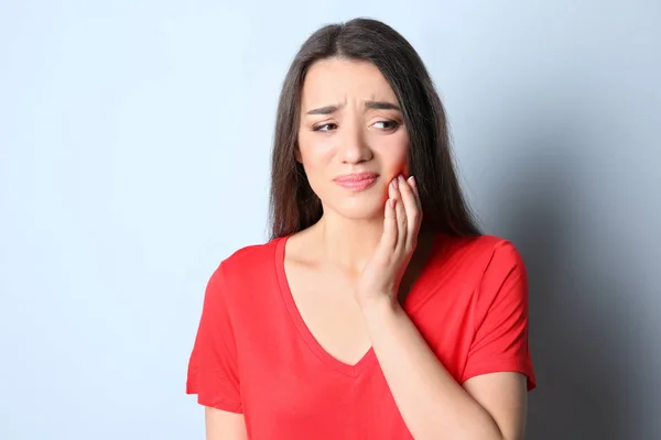 Frau mit empfindlichen Zähnen auf farbigem Hintergrund — Stockfoto