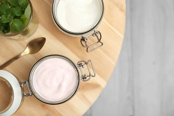 Frascos con diferentes yogures en la mesa — Foto de Stock