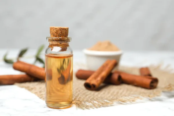 Bottle with cinnamon essential oil on table — Stock Photo, Image